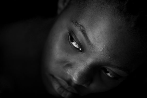 A Haitian girl looms out of the darkness in the back of a tap tap in Jacme,