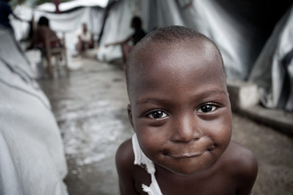 A young boy smiles despite the conditions in a tent city in Port-au-Prince, just months after the January 2010 earthquake.